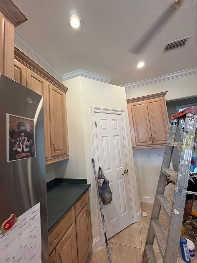 Kitchen after — wallpaper removed, walls painted a clean soft neutral with white trim